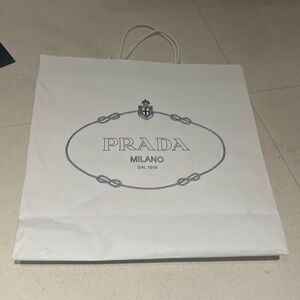 Two Prada medium and large sized paper bags.